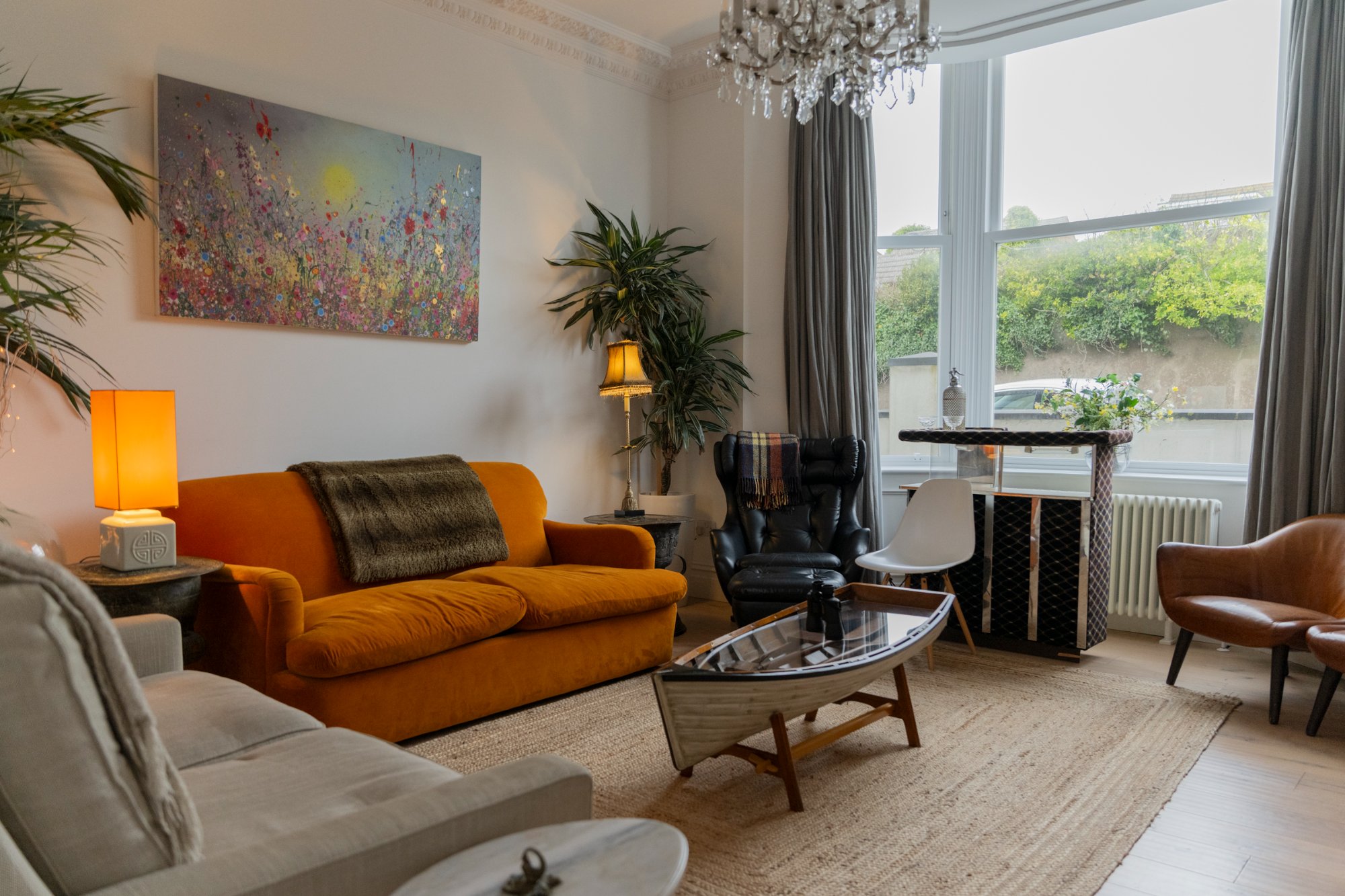 Lounge with mustard sofa, chandelier and eclectic decor